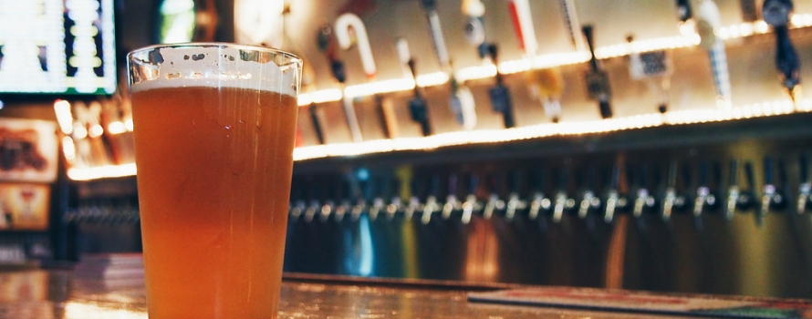 One poured beer in front of many taps on a bar